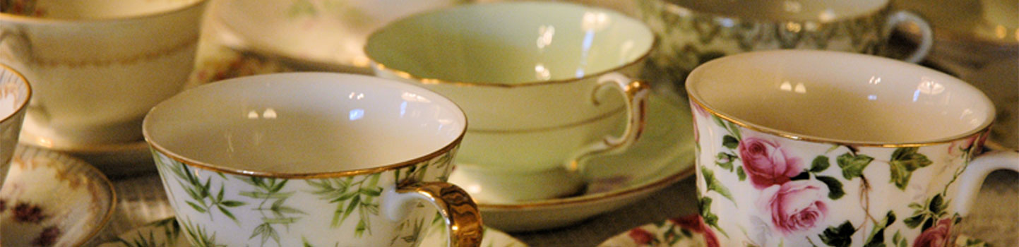 Assorted China Tea cups with floral patterns in red and pink, and green and white, and banded pale green