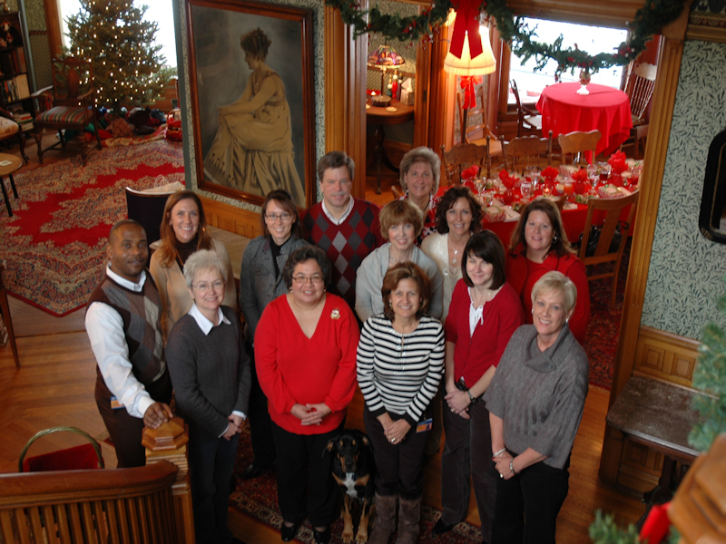 Office staff gathers mid holiday greenery, berries and bows at Stuart Avenue BnB
