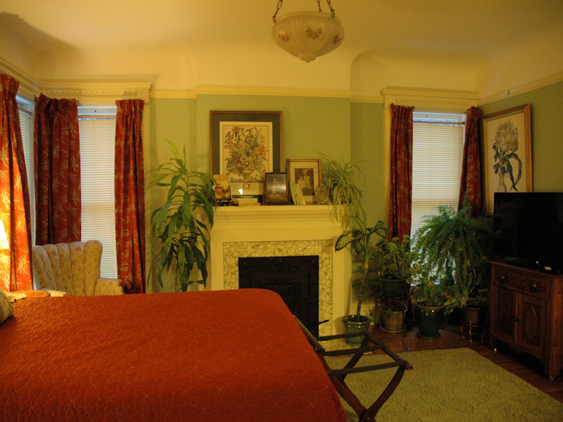 Queen Bed facing flatscreen TV and Victorian fireplace.